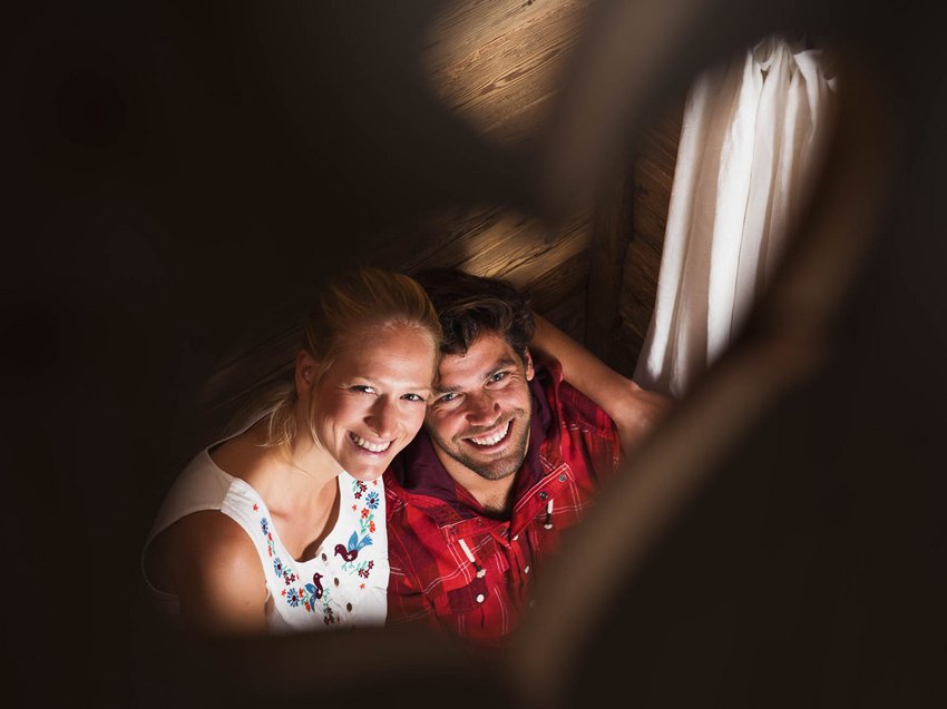 Erholungsurlaub im Chalet im Stubaital Lächelndes Paar in einer Holzhütte durch ein herzförmiges Objekt fotografiert