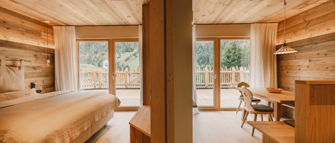 Erholungsurlaub im Chalet im Stubaital Gemütliches Holz-Zimmer mit Bett und Essbereich mit Bergblick