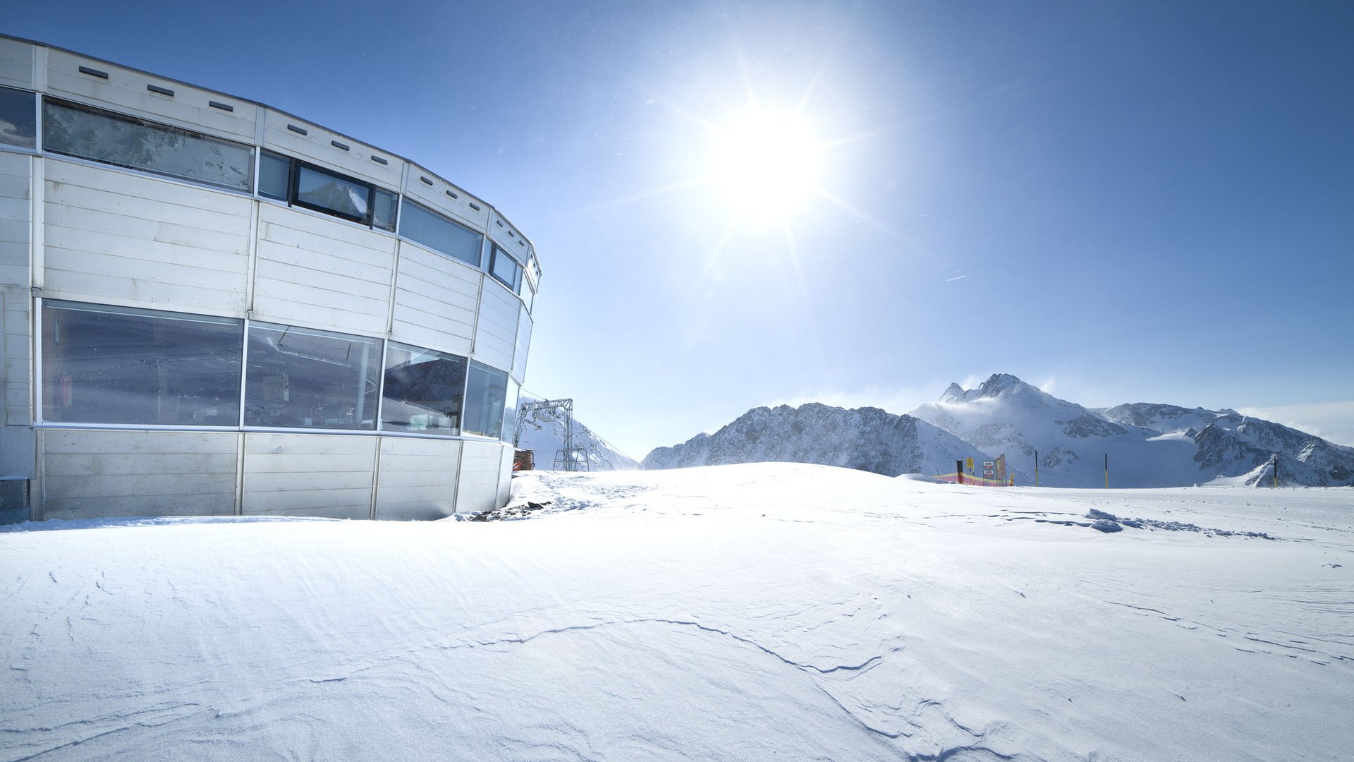 The top sights to see in Stubaital Snow-covered mountain plateau with bright sunshine and building on the left